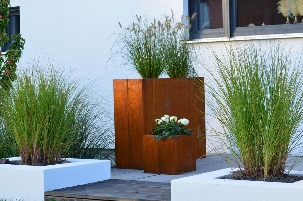 Hochbeet Monterosso auf einer modernen Terrasse neben einem ELEO Pflanzkübel | Cortenstahl Hochbeet Monterosso auf einer modernen Terrasse neben einem ELEO Pflanzkübel | Cortenstahl