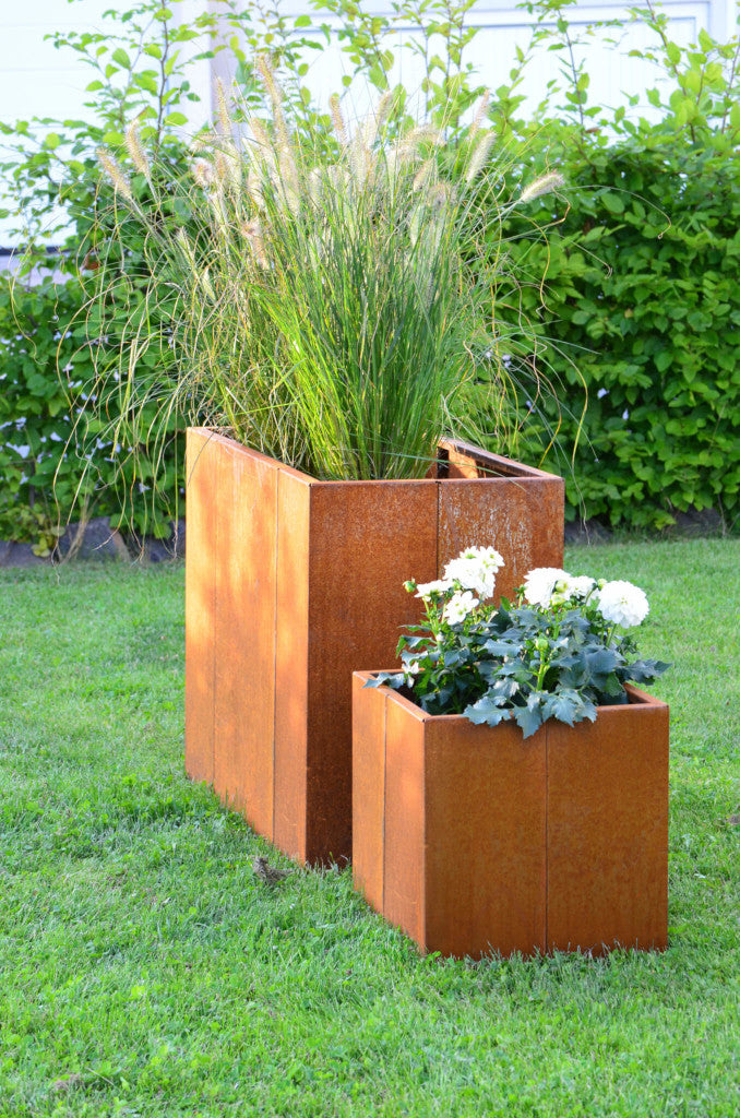 Pflanzkübel Vernazza 40x40x40 cm und Hochbeet aus Cortenstahl in einem grünen Garten Pflanzkübel Vernazza 40x40x40 cm und Hochbeet aus Cortenstahl in einem grünen Garten