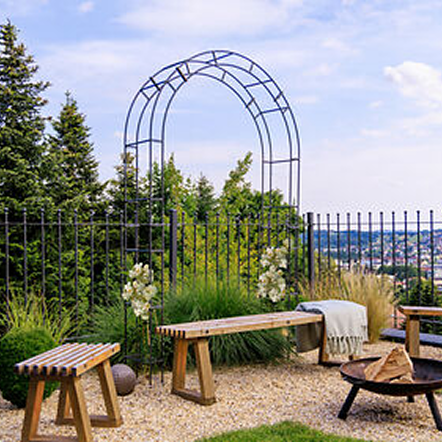 Rosenbogen Cremona in anthrazit pulverbeschichtet vor einer Feuerstelle platziert.